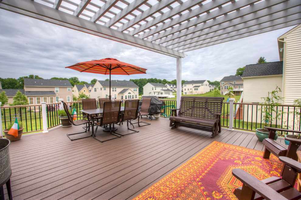 Mid-sized transitional backyard deck photo with a pergola