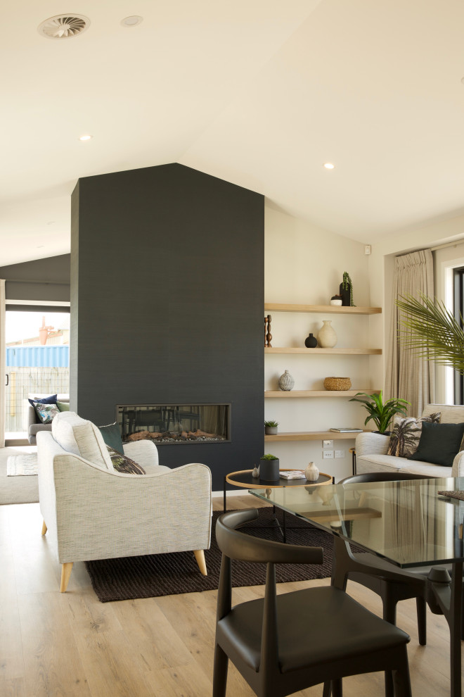 Réalisation d'une salle de séjour minimaliste de taille moyenne et ouverte avec un mur bleu, sol en stratifié, une cheminée standard, un sol marron, un plafond voûté et du papier peint.