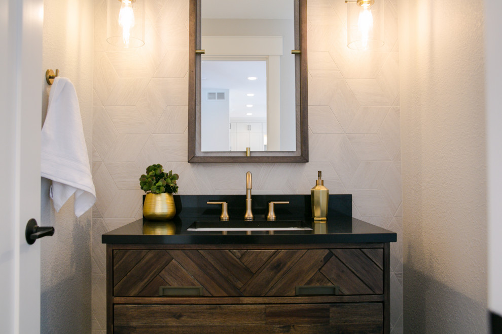 This is an example of a medium sized classic cloakroom in Denver with freestanding cabinets, dark wood cabinets, a one-piece toilet, beige tiles, ceramic tiles, white walls, porcelain flooring, a submerged sink, engineered stone worktops, black floors, black worktops and a freestanding vanity unit.