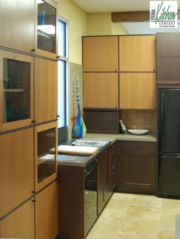 サンルイスオビスポにあるアジアンスタイルのおしゃれなキッチン (一体型シンク、フラットパネル扉のキャビネット、濃色木目調キャビネット、タイルカウンター、黒い調理設備) の写真