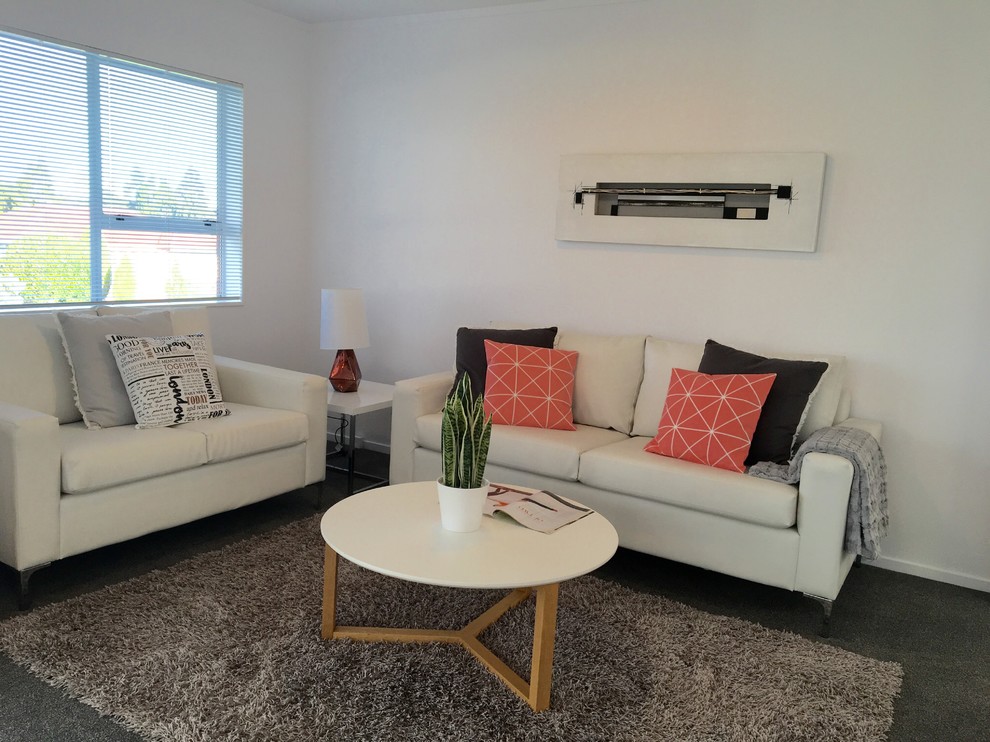 Photo of a small modern open concept living room in Auckland with white walls, carpet, no fireplace and grey floor.
