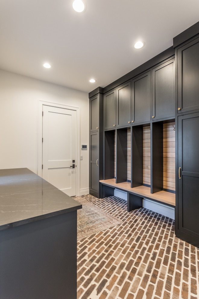 Mid-sized transitional brick floor and multicolored floor mudroom photo with a white front door