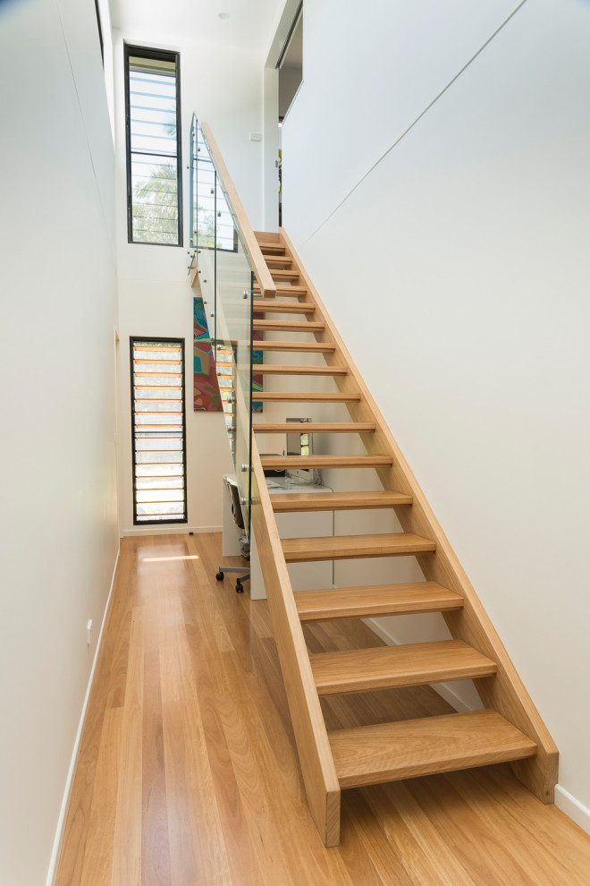 Photo of a large beach style wood straight staircase in Other with wood risers and wood railing.