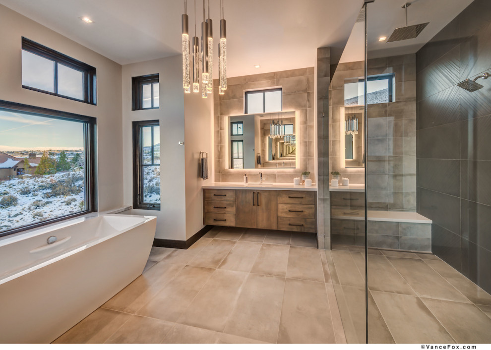 This is an example of a large contemporary master bathroom in Other with flat-panel cabinets, brown cabinets, a freestanding tub, a curbless shower, a two-piece toilet, gray tile, grey walls, ceramic floors, an undermount sink, a sliding shower screen and beige benchtops.
