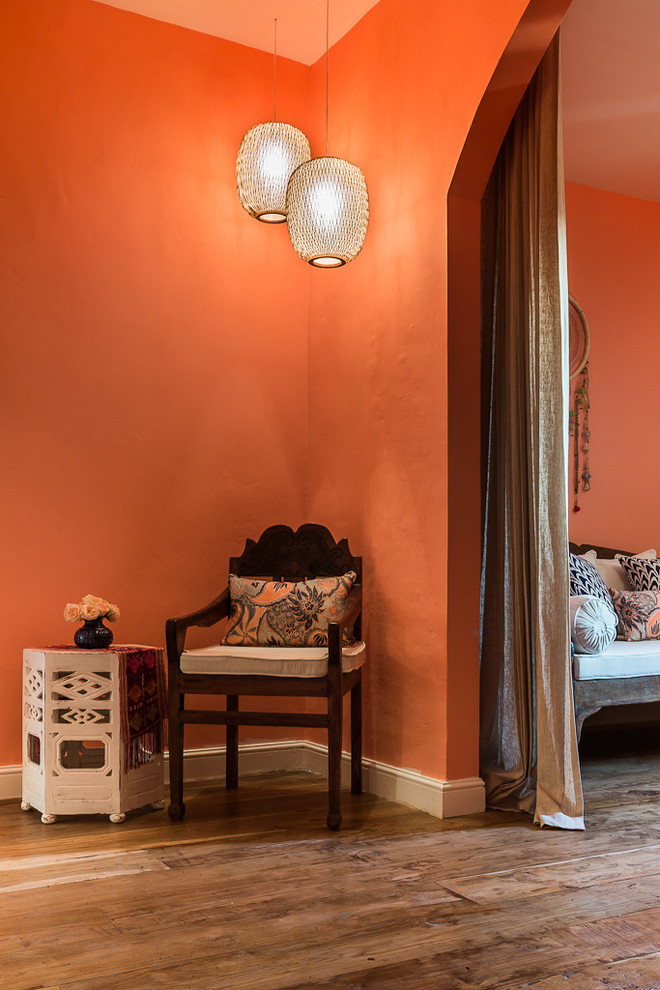 Design ideas for a large transitional master bedroom in Other with orange walls and medium hardwood floors.
