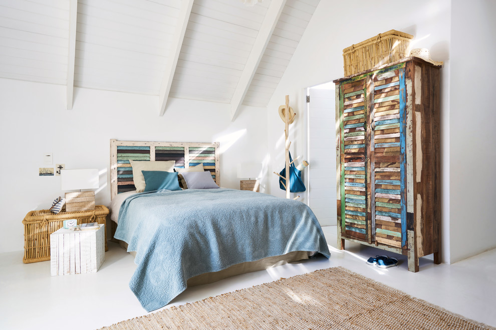 Design ideas for a mid-sized beach style master bedroom in London with white walls and white floor.