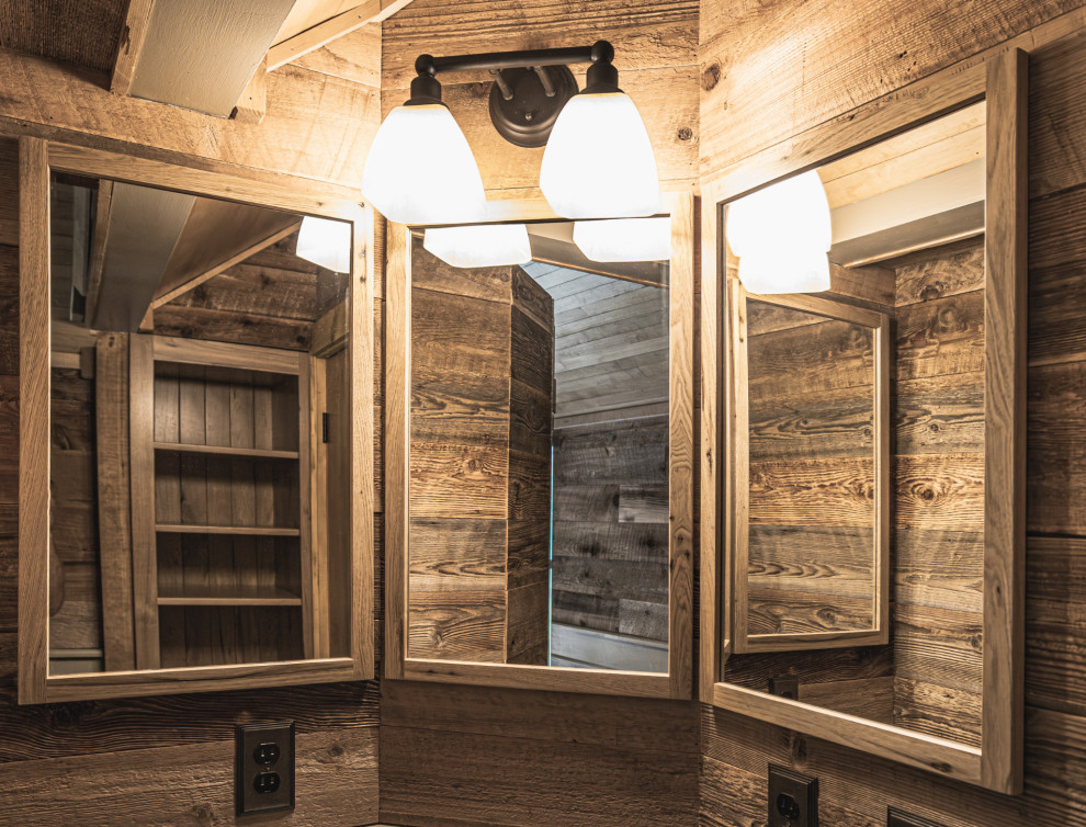 Example of a mountain style porcelain tile, single-sink, wood ceiling and wainscoting shower bench design with shaker cabinets, an undermount sink, granite countertops, a hinged shower door, black countertops and a built-in vanity