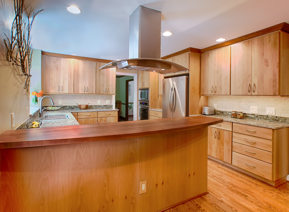 Mid-sized transitional u-shaped medium tone wood floor eat-in kitchen photo in Raleigh with a double-bowl sink, flat-panel cabinets, light wood cabinets, granite countertops, green backsplash, glass tile backsplash, stainless steel appliances, beige walls and a peninsula