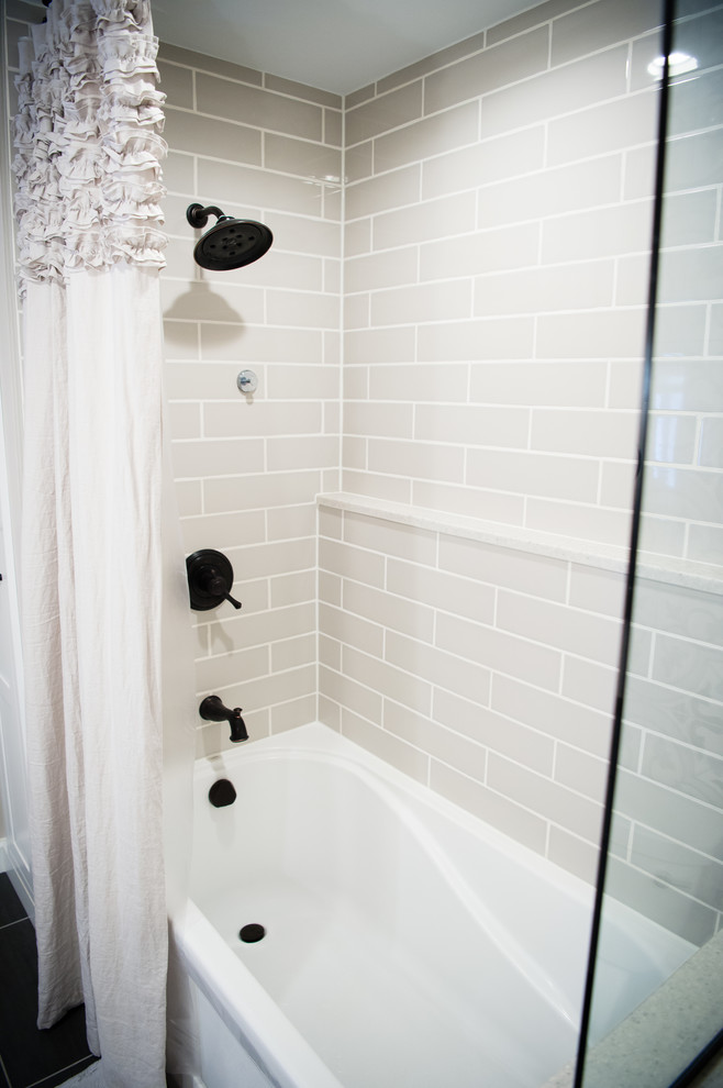 Photo of a mid-sized transitional master bathroom in Other with shaker cabinets, grey cabinets, an alcove tub, a two-piece toilet, gray tile, ceramic tile, an undermount sink, quartzite benchtops, a shower curtain and white benchtops.