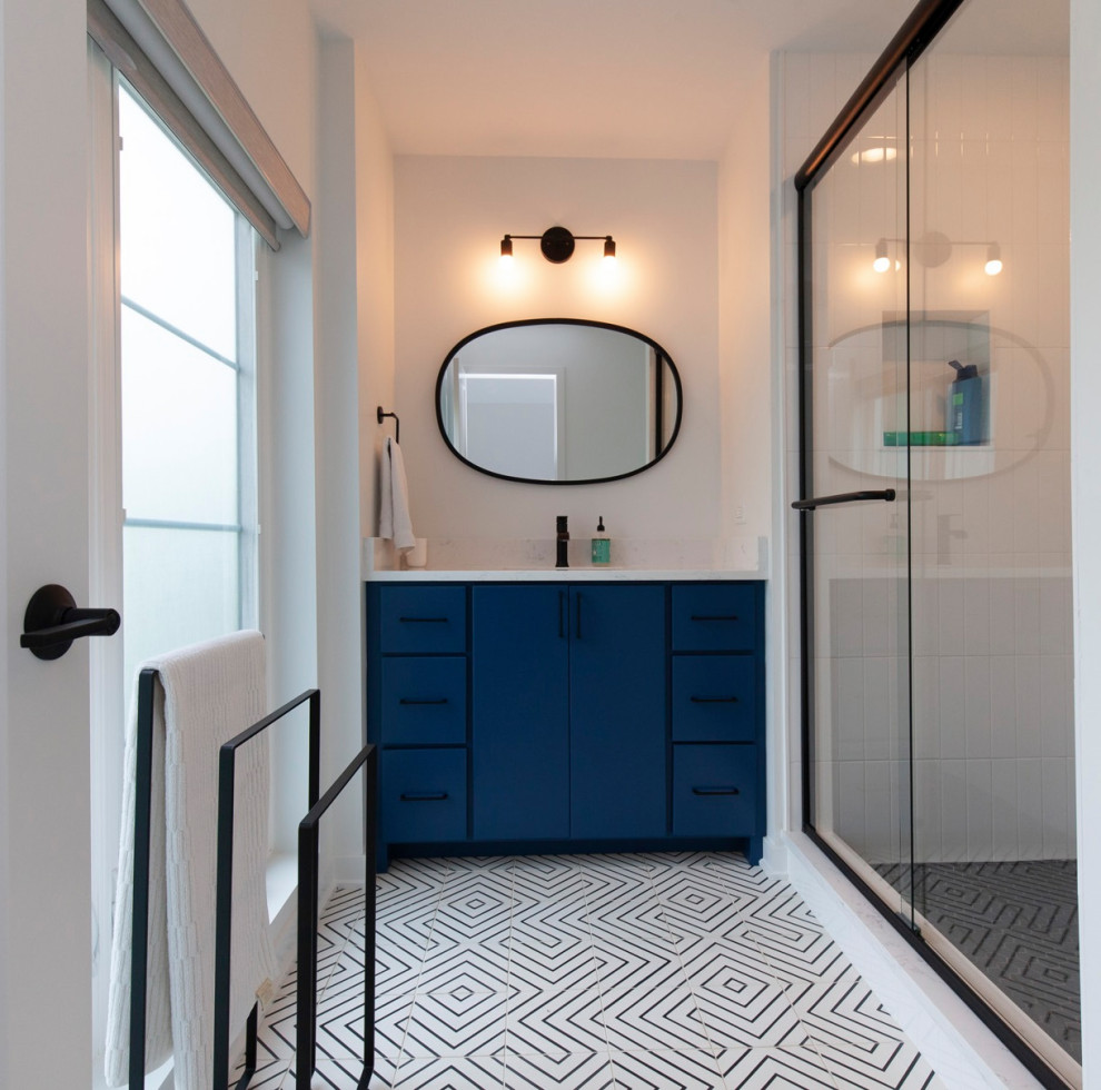 Inspiration for a large modern 3/4 bathroom in Chicago with flat-panel cabinets, blue cabinets, an alcove shower, white tile, subway tile, white walls, porcelain floors, engineered quartz benchtops, black floor, a sliding shower screen, white benchtops, a niche, a single vanity and a built-in vanity.