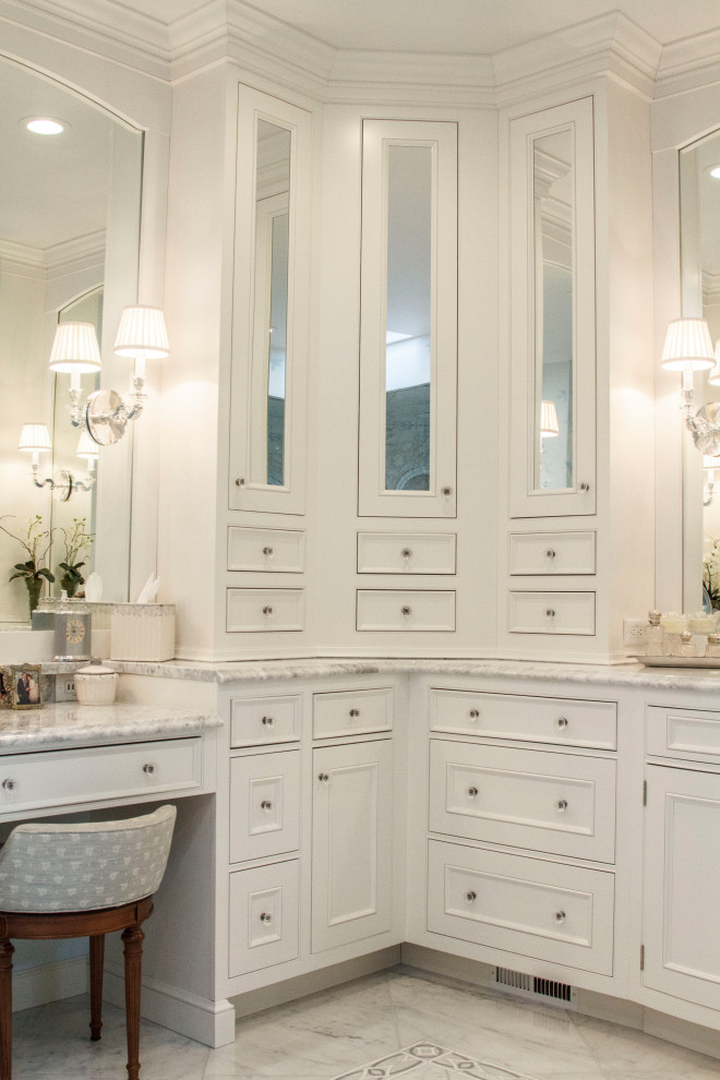 Design ideas for a large traditional master bathroom in St Louis with furniture-like cabinets, white cabinets, a freestanding tub, an alcove shower, a one-piece toilet, white tile, marble, blue walls, marble floors, an undermount sink, marble benchtops, white floor, a hinged shower door, white benchtops, an enclosed toilet, a double vanity, a built-in vanity and wallpaper.