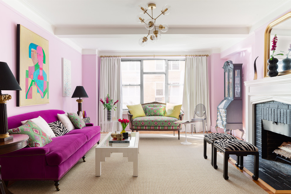 Inspiration for a mid-sized eclectic enclosed living room in New York with pink walls, medium hardwood floors, a standard fireplace, a brick fireplace surround, brown floor and no tv.