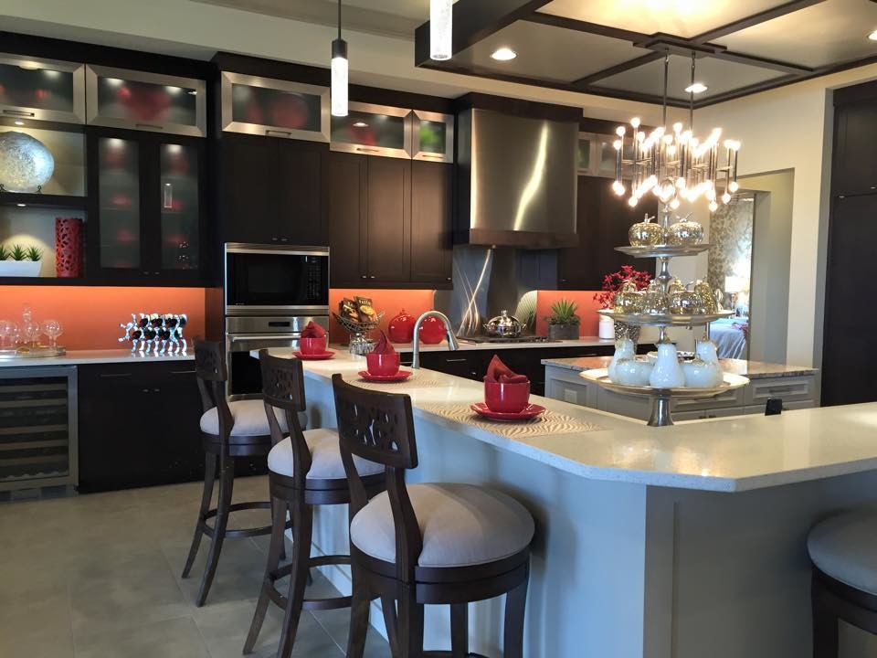 Example of a mid-sized minimalist single-wall travertine floor and beige floor enclosed kitchen design in Tampa with an undermount sink, shaker cabinets, dark wood cabinets, limestone countertops, metallic backsplash, metal backsplash, stainless steel appliances and two islands