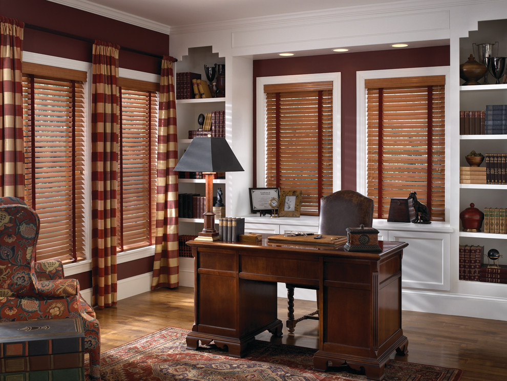 Photo of a large traditional study room in Atlanta with red walls, dark hardwood floors, no fireplace, a freestanding desk and brown floor.