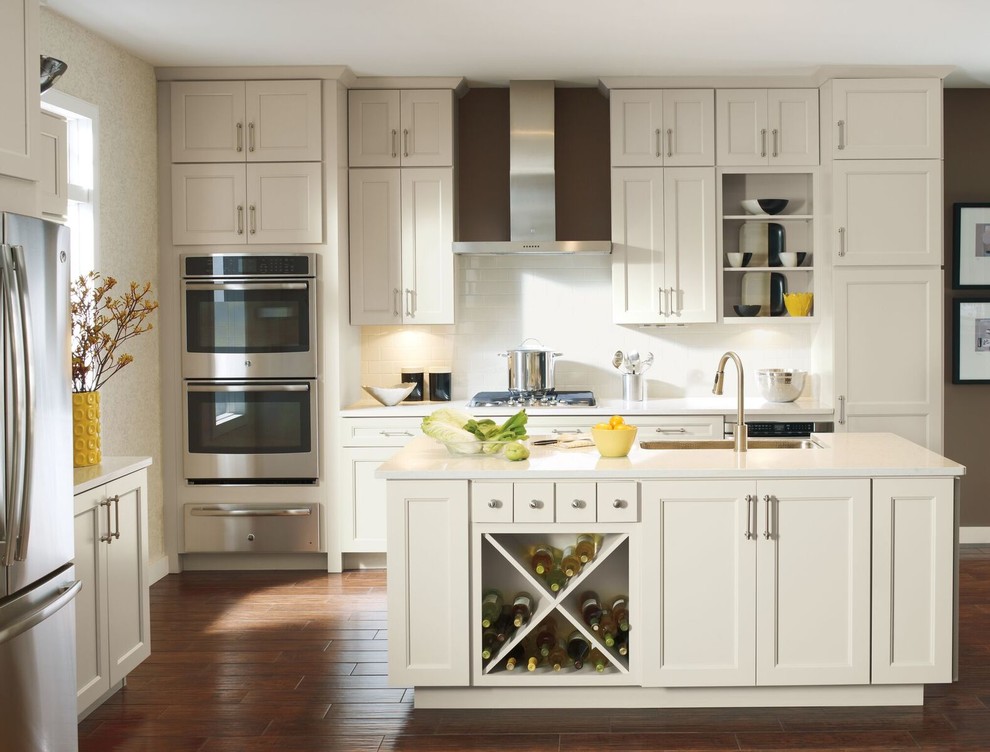 Example of a mid-sized transitional l-shaped porcelain tile and beige floor enclosed kitchen design with an undermount sink, raised-panel cabinets, light wood cabinets, granite countertops, beige backsplash, mosaic tile backsplash, stainless steel appliances and an island