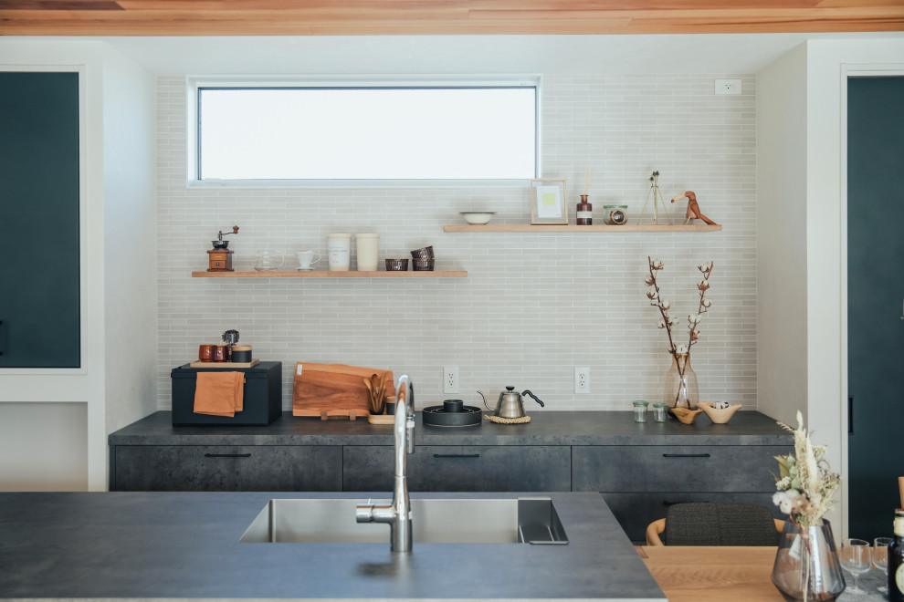 Exemple d'une cuisine ouverte linéaire tendance avec des portes de placard noires, un sol en bois brun, un sol beige, plan de travail noir et un plafond en bois.