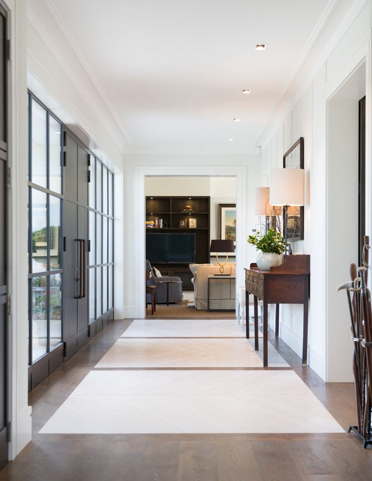 This is an example of a contemporary foyer in Christchurch with white walls, limestone floors, a double front door, a dark wood front door and multi-coloured floor.