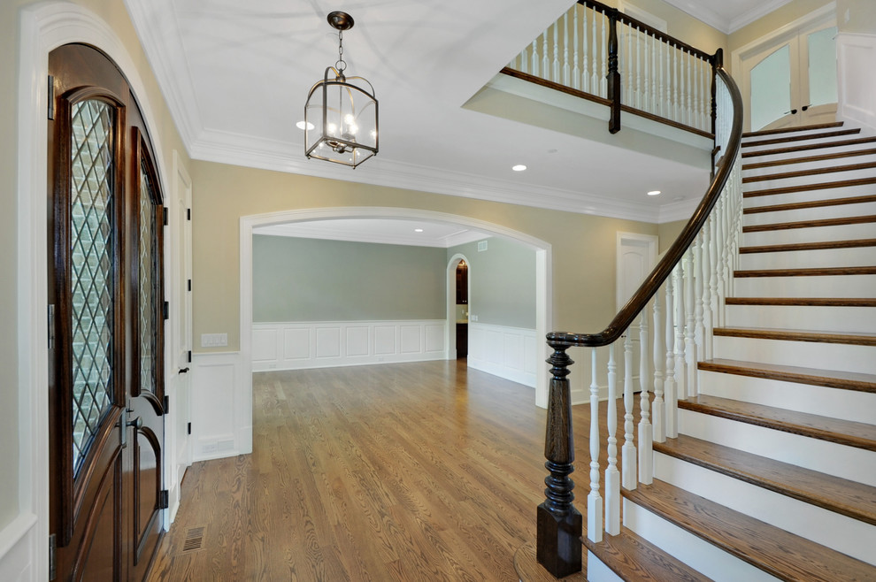 Large traditional foyer in Chicago with multi-coloured walls, medium hardwood floors, a double front door and a dark wood front door.