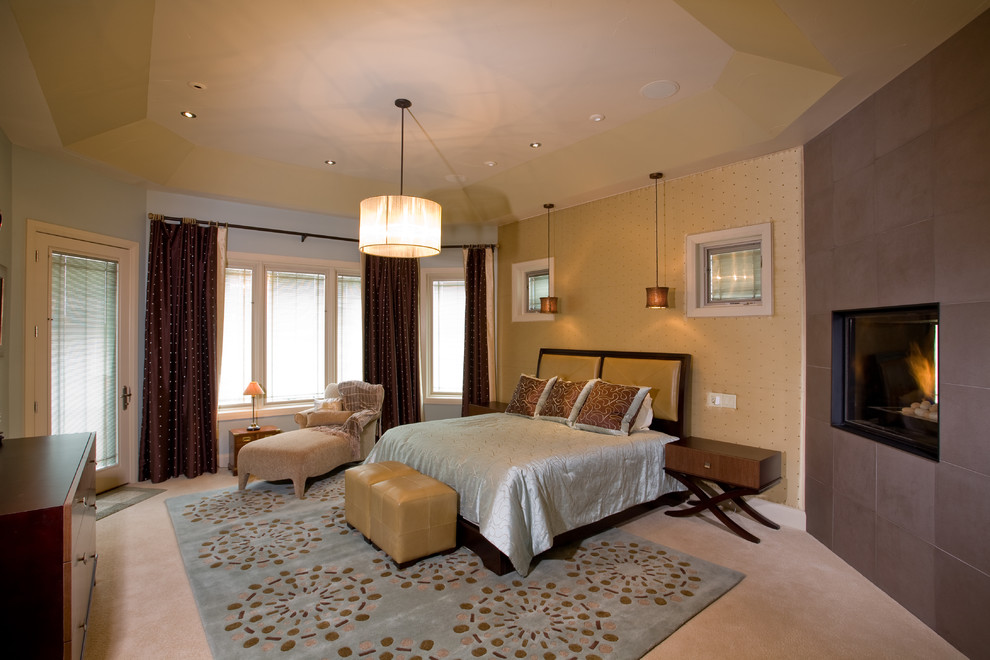 Design ideas for a large transitional master bedroom in Denver with beige walls, carpet, a two-sided fireplace and a tile fireplace surround.