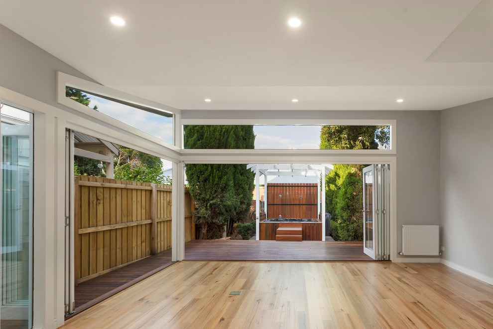 Photo of a small beach style backyard deck in Melbourne with with privacy feature and a pergola.