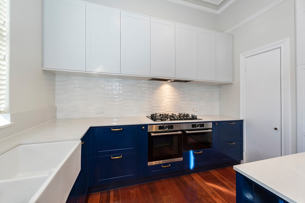 Photo of a large transitional l-shaped eat-in kitchen in Perth with a farmhouse sink, shaker cabinets, blue cabinets, quartz benchtops, medium hardwood floors and with island.
