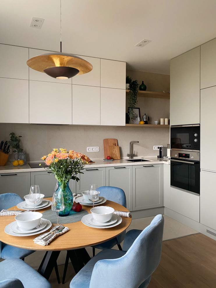 Inspiration for a contemporary l-shaped open plan kitchen in Moscow with an undermount sink, grey cabinets, solid surface benchtops, beige splashback, porcelain splashback, porcelain floors, beige floor and white benchtop.