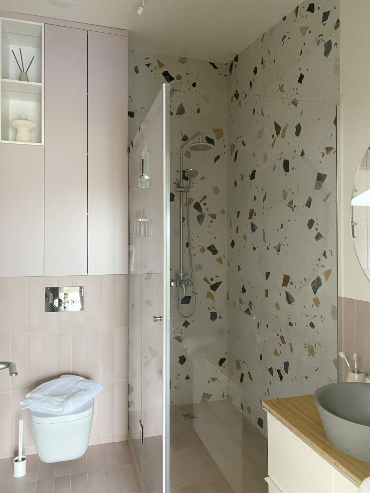 Klassisk inredning av ett mellanstort badrum med dusch, med släta luckor, vita skåp, en hörndusch, en vägghängd toalettstol, flerfärgad kakel, keramikplattor, beige väggar, klinkergolv i porslin, ett nedsänkt handfat och rosa golv
