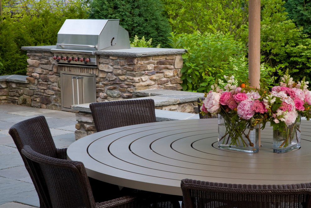 Large traditional backyard patio in Chicago with natural stone pavers and an outdoor kitchen.