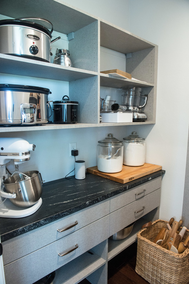 This is an example of a large country gender-neutral walk-in wardrobe in Other with flat-panel cabinets, grey cabinets and medium hardwood floors.