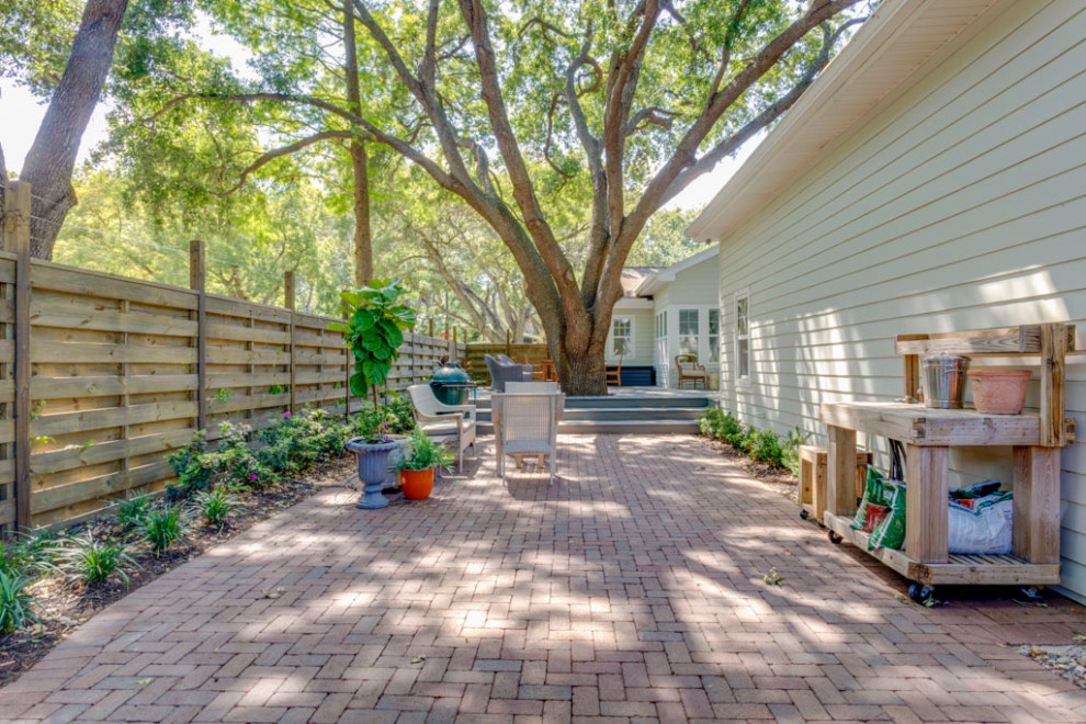 Inspiration for a mid-sized traditional backyard shaded formal garden in Tampa with with privacy feature and brick pavers.