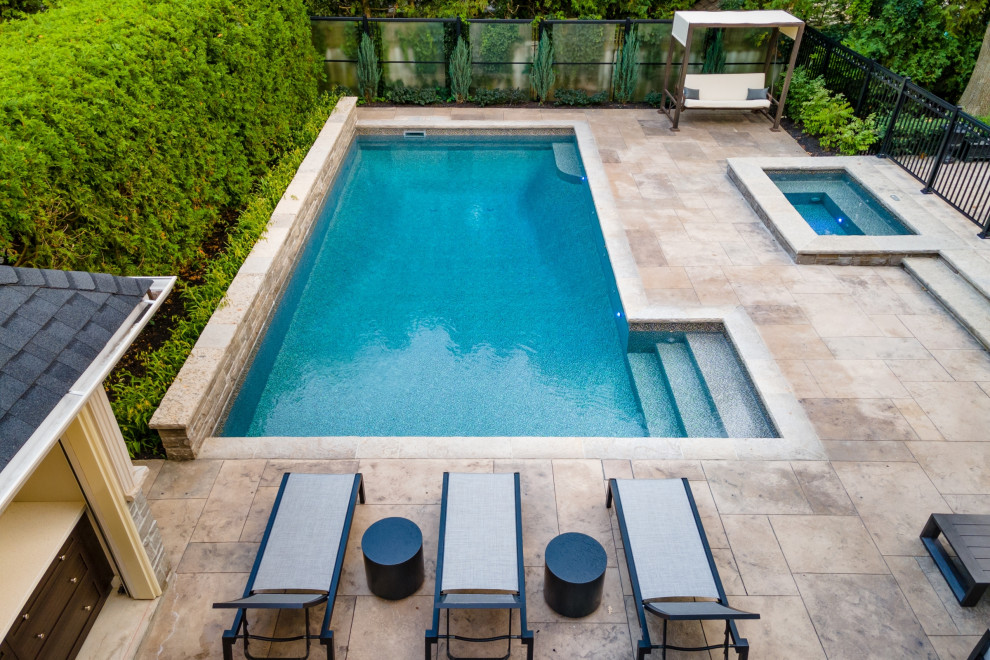 Imagen de piscina tradicional renovada de tamaño medio rectangular en patio trasero con paisajismo de piscina y suelo de hormigón estampado