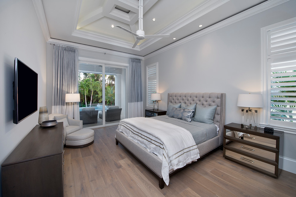 Photo of a transitional master bedroom in Miami with grey walls, medium hardwood floors and brown floor.