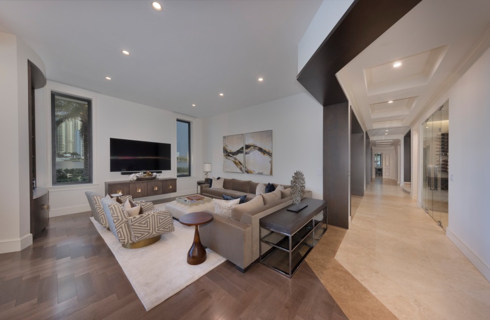 Klassisches Wohnzimmer ohne Kamin mit gelber Wandfarbe, TV-Wand und braunem Boden in Miami