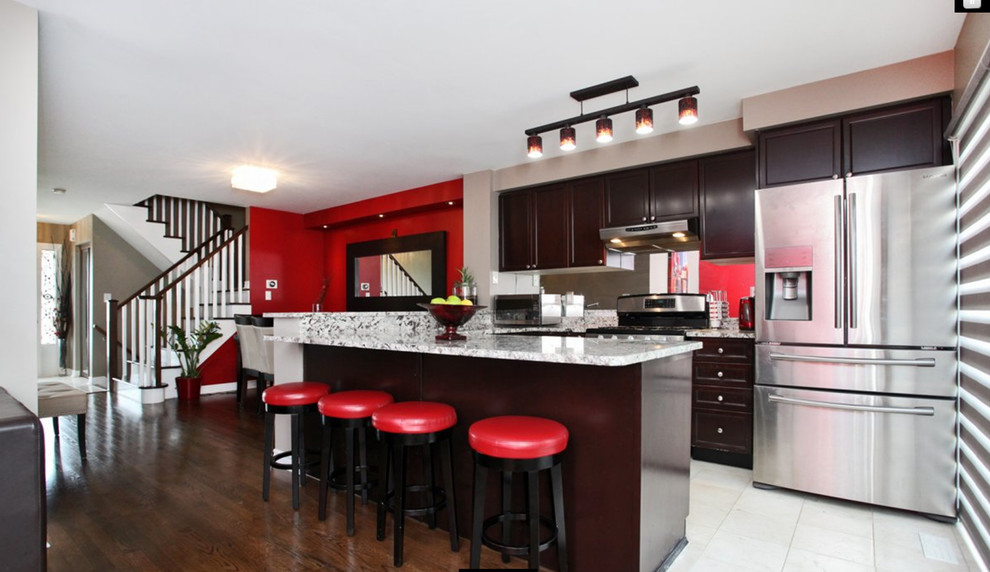 Example of a transitional u-shaped marble floor and beige floor eat-in kitchen design in Toronto with dark wood cabinets, marble countertops, mirror backsplash, stainless steel appliances and an island