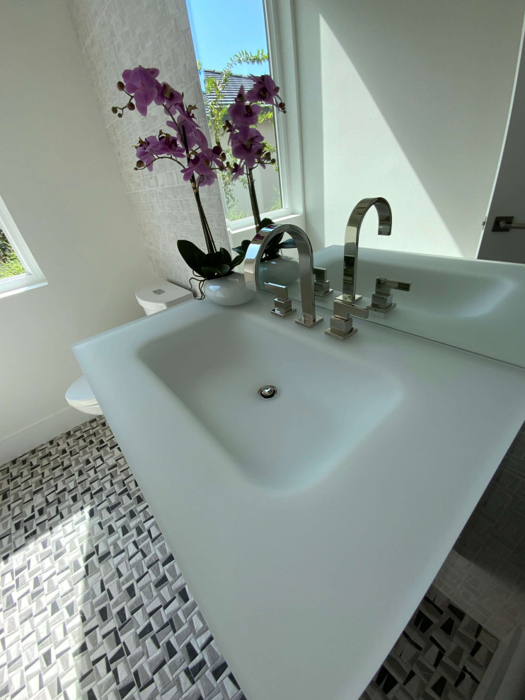 Inspiration for a medium sized modern cloakroom in Austin with flat-panel cabinets, black cabinets, a one-piece toilet, white tiles, ceramic tiles, white walls, mosaic tile flooring, an integrated sink, glass worktops, brown floors, white worktops, a floating vanity unit, all types of ceiling and all types of wall treatment.