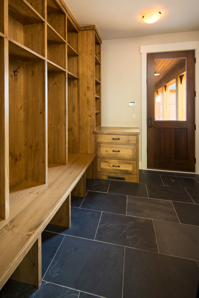 Mid-sized country mudroom in Minneapolis with white walls, slate floors, a single front door and a medium wood front door.