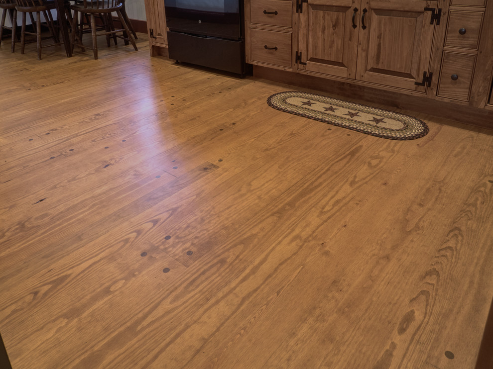 Example of a mid-sized mountain style l-shaped medium tone wood floor eat-in kitchen design with medium tone wood cabinets and no island
