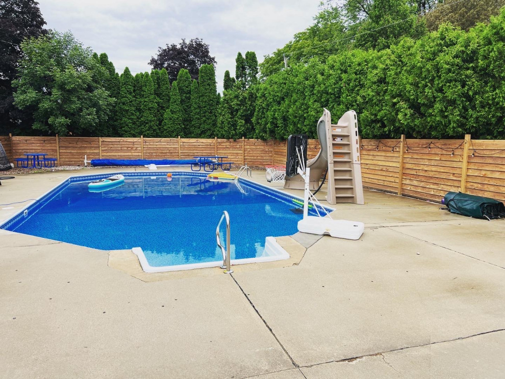 This is an example of an expansive modern backyard full sun outdoor sport court for summer in Milwaukee with with privacy feature, gravel and a wood fence.
