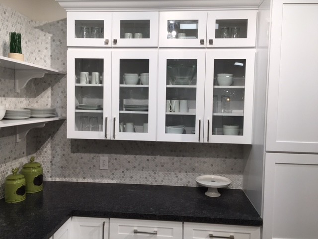 Example of a mid-sized transitional l-shaped dark wood floor and gray floor enclosed kitchen design in Orange County with white cabinets, gray backsplash, mosaic tile backsplash, stainless steel appliances, shaker cabinets, granite countertops and an island
