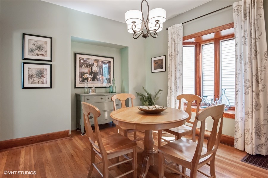 This is an example of a mid-sized eclectic separate dining room in Chicago with green walls and medium hardwood floors.