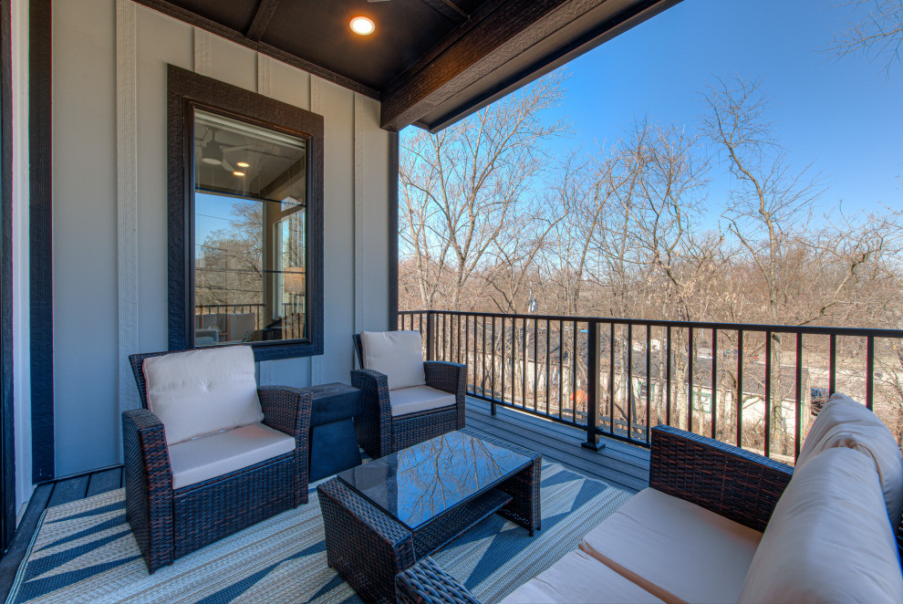 This is an example of a medium sized contemporary metal railing balcony in Indianapolis with a roof extension.