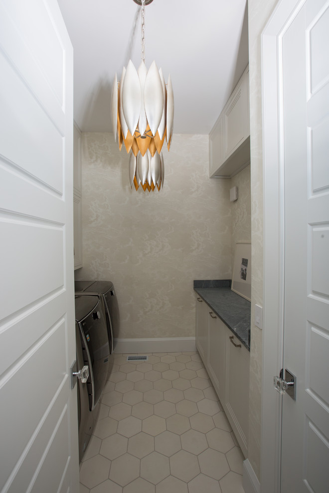 Inspiration for a small modern galley dedicated laundry room in Indianapolis with recessed-panel cabinets, white cabinets, soapstone benchtops, concrete floors, a side-by-side washer and dryer and white floor.