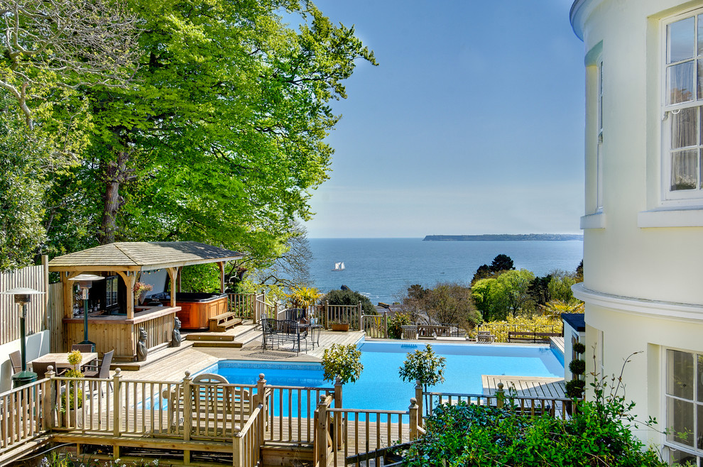 Mid-sized mediterranean side yard custom-shaped pool in Devon with a water feature and decking.