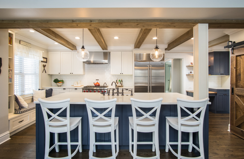 Inspiration for a country kitchen in Chicago with a farmhouse sink, shaker cabinets, white cabinets, quartzite benchtops, white splashback, ceramic splashback, stainless steel appliances, dark hardwood floors, with island, brown floor and white benchtop.
