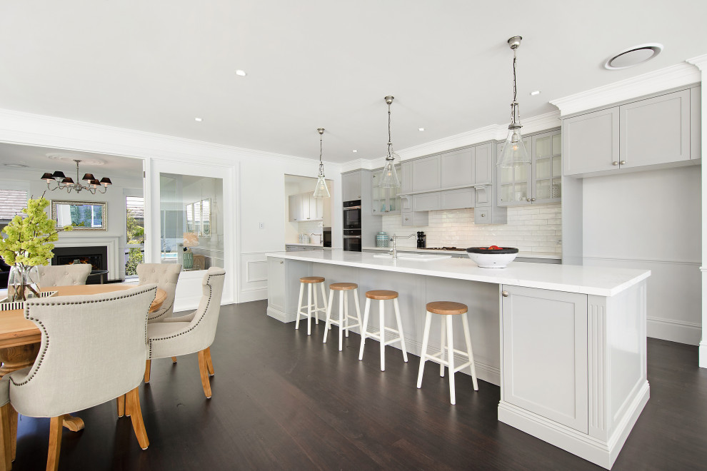 Design ideas for a large beach style galley eat-in kitchen in Sydney with a farmhouse sink, shaker cabinets, grey cabinets, marble benchtops, white splashback, subway tile splashback, stainless steel appliances, dark hardwood floors, with island and grey benchtop.