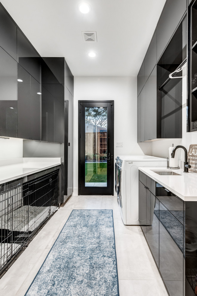 Design ideas for a large contemporary galley dedicated laundry room in Dallas with flat-panel cabinets, black cabinets, white walls, porcelain floors, a side-by-side washer and dryer, black floor and white benchtop.