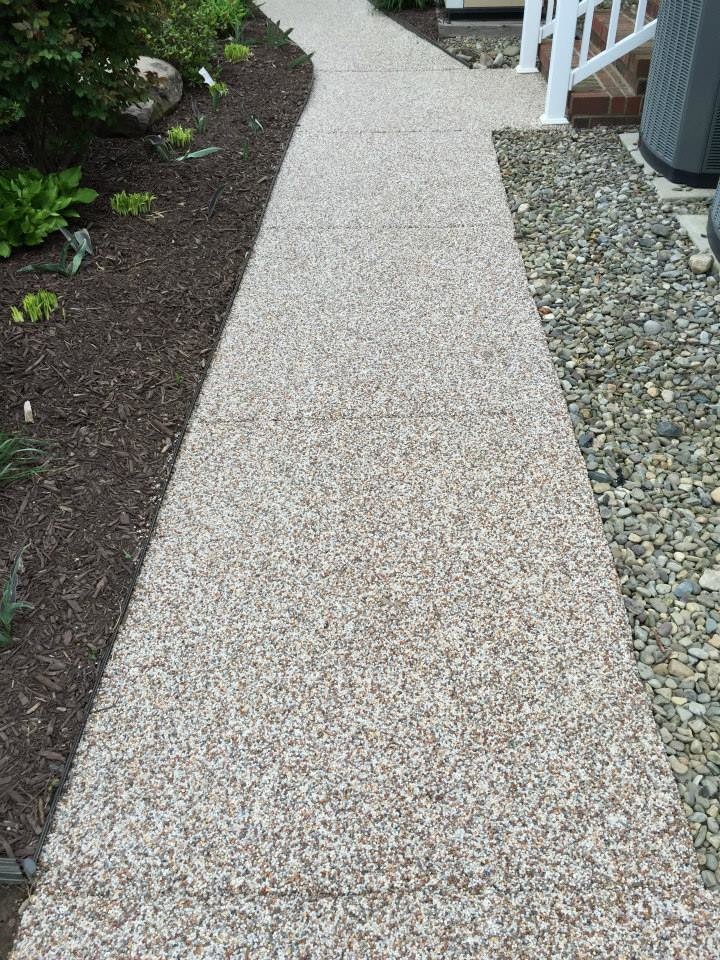 Photo of a mid-sized transitional backyard concrete and custom-shaped landscaping.