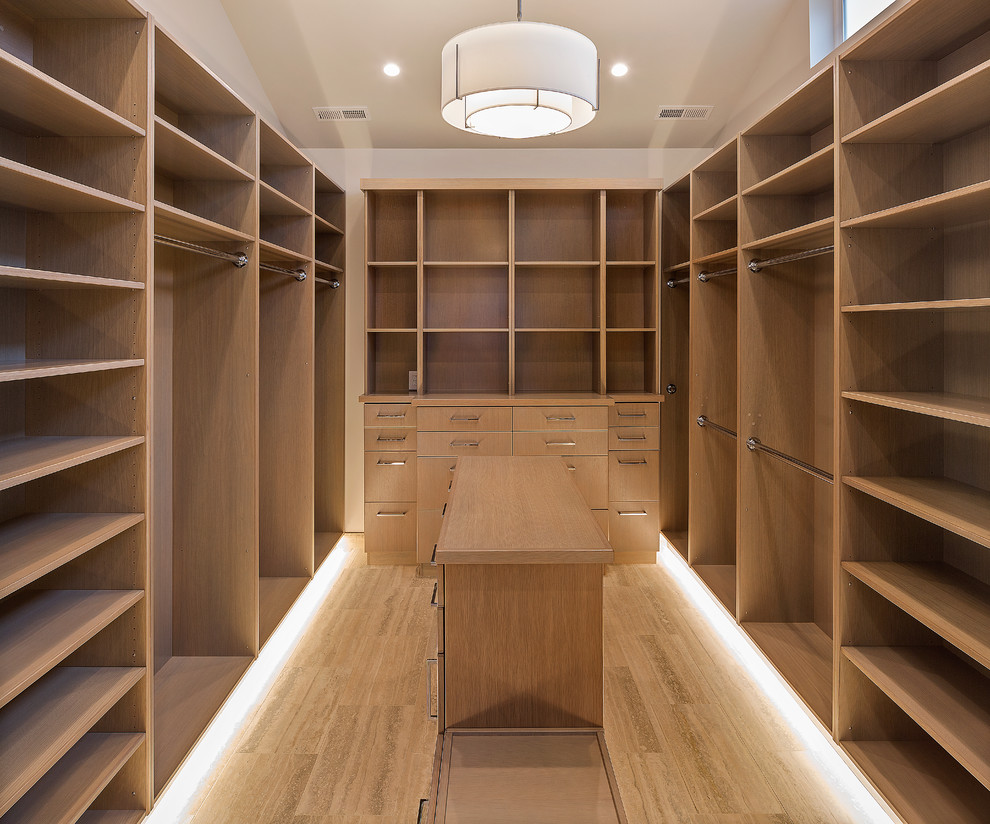 Inspiration for a mid-sized transitional women's walk-in wardrobe in Seattle with flat-panel cabinets, light wood cabinets, travertine floors and beige floor.