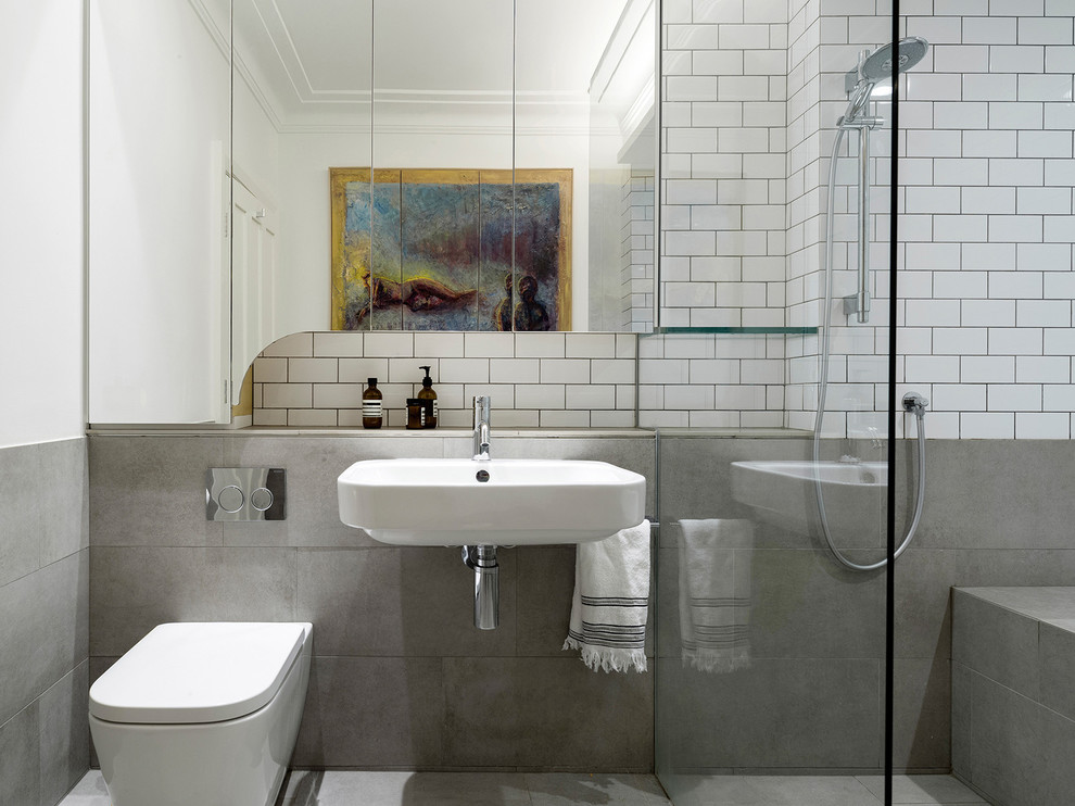 This is an example of a contemporary bathroom in Sydney with a wall-mount toilet, gray tile, white tile, subway tile, multi-coloured walls and a wall-mount sink.