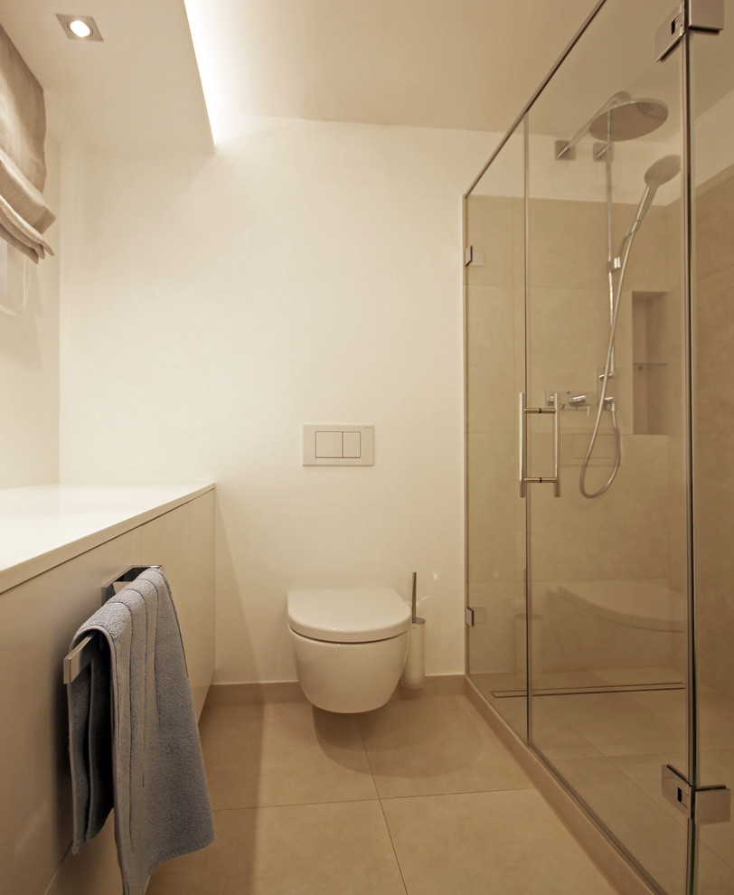 Inspiration for a small contemporary 3/4 wet room bathroom in Munich with flat-panel cabinets, white cabinets, a wall-mount toilet, beige tile, ceramic tile, white walls, ceramic floors, a vessel sink, solid surface benchtops, beige floor and white benchtops.